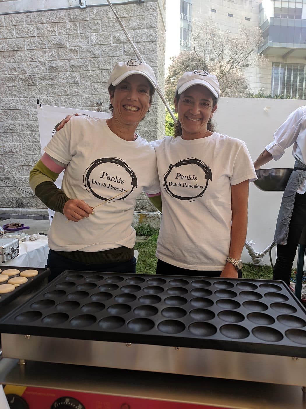 The Pankis Dutch Pancakes team beside the poffertjes griddle at a Cincinnati event
