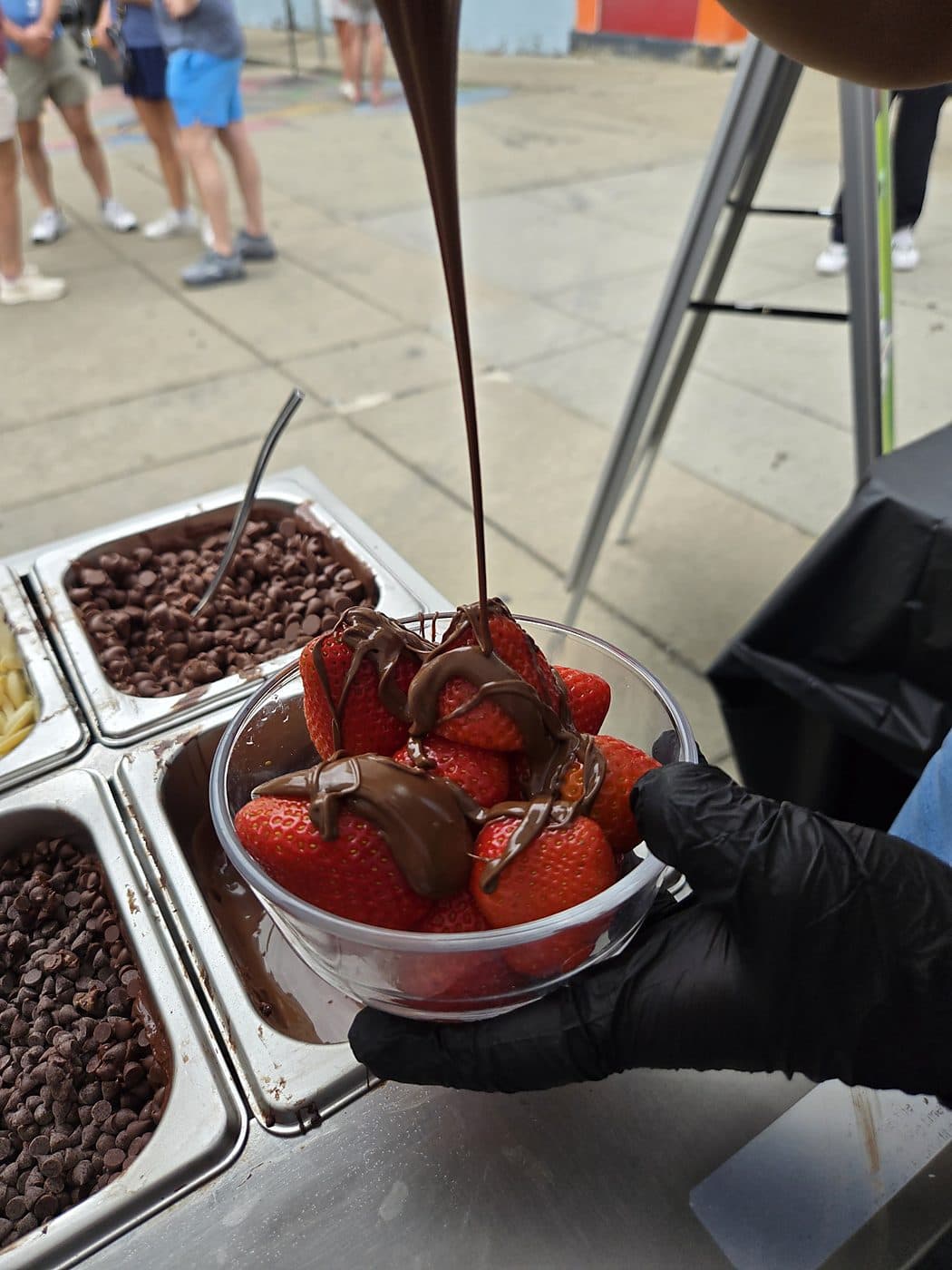 Melted chocolate poured over a bowl of fresh strawberries at a Pankis event
